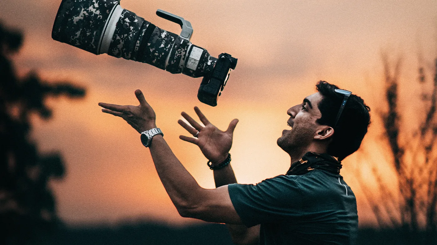 Suyash Keshari tossing a long-lens camera into the air at sunset