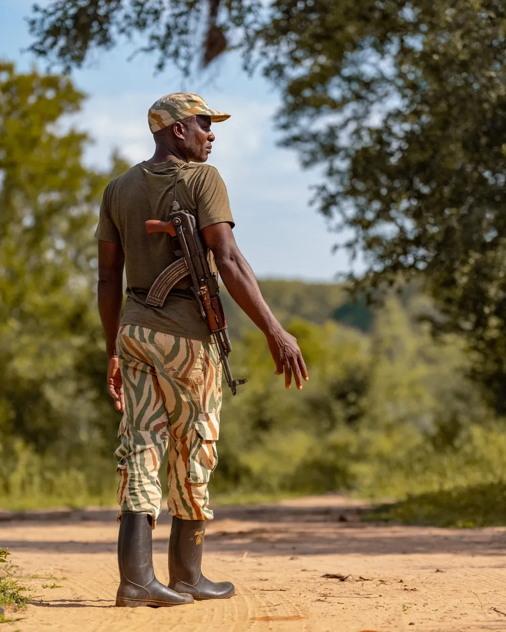 A forest guard on patrol, seen from behind on a forest road